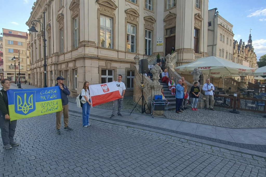 Grupa ludzi trzyma dwie flagi - polska i ukraińską.