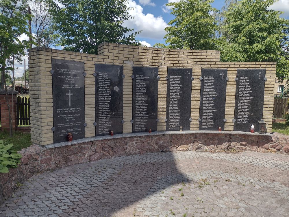 Na zdjęciu podłużny memoriał upamiętniający zamordowanych Polaków z tej miejscowości. Lista około 200 nazwisk umieszczona na pięciu tablicach. Jedna tablica wprowadzajaca