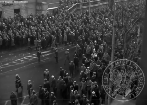 Zdjęcie czarno-białe. Widać duży tłum idący ulicą. Zdjęcie z 1968 roku z Warszawy