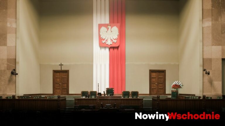 Sala posiedzeń Sejmu RP z polską flagą i godłem w centralnym punkcie.