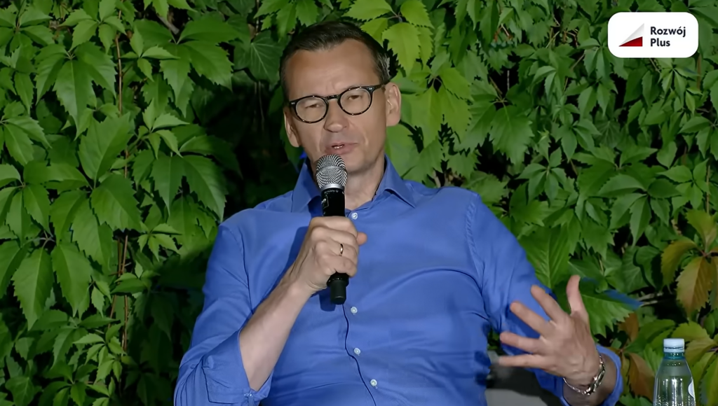 A man in a blue shirt with a microphone.