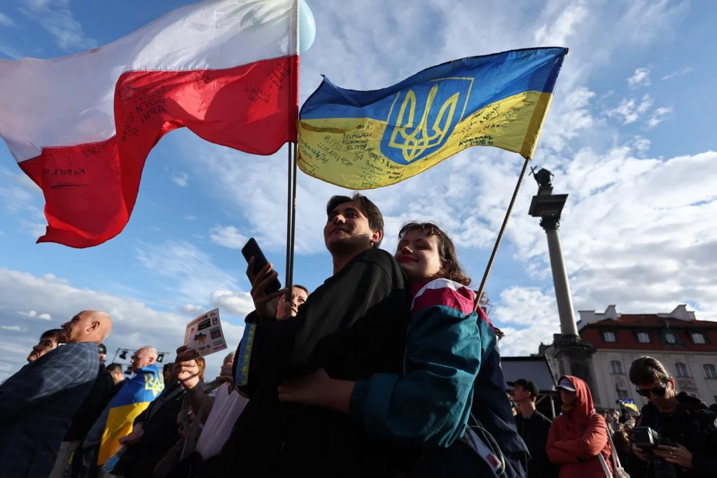Polak i Ukrainka z flagami Polski i Ukrainy na wiecu solidarności w Warszawie