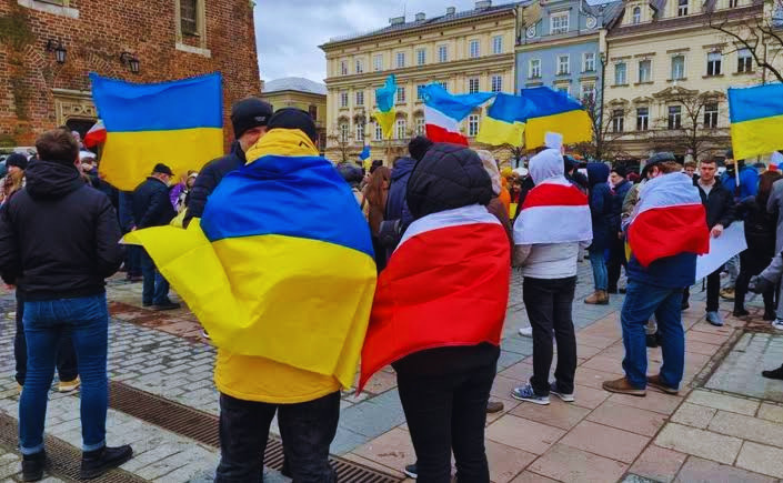 Mieszkańcy owinięci we flagi Ukrainy i Polski podczas manifestacji solidarności