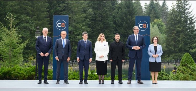 Przywódcy państw uczestniczących w szczycie Karpackiej Ósemki (C8) na tle logo wydarzenia, wrzesień 2026