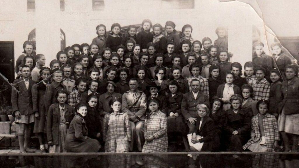 Grupa polskich dzieci i dorosłych na historycznej fotografii w Isfahanie podczas II wojny światowej.